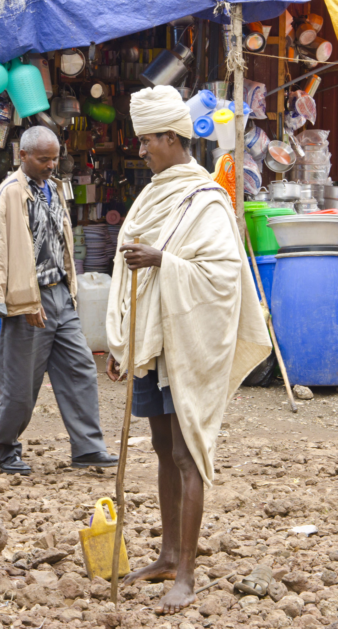 Ethiopian man with stave standing in front of market stall, Bahir Dar