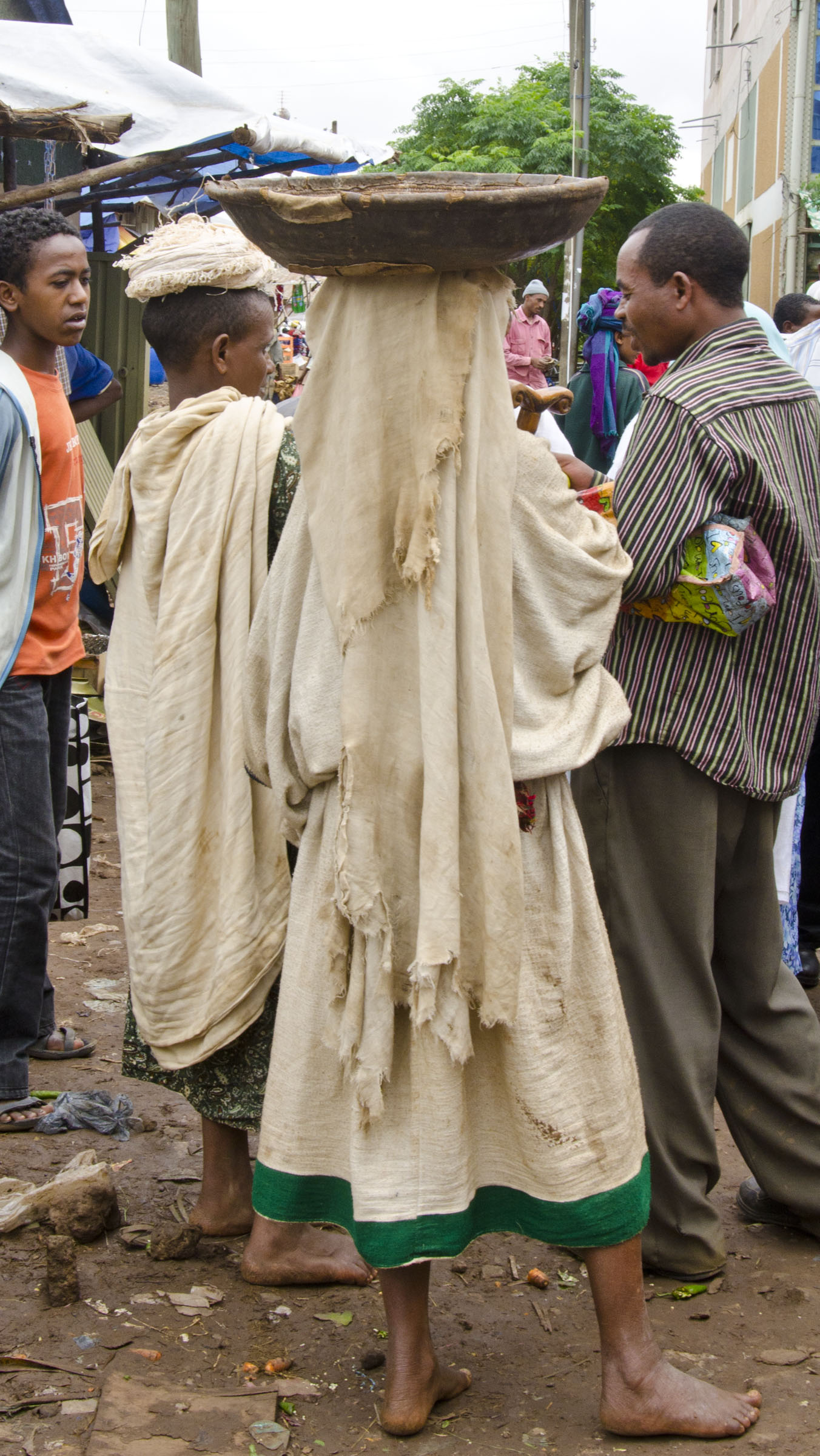 Ethiopian woman carrying wooden bowl on head