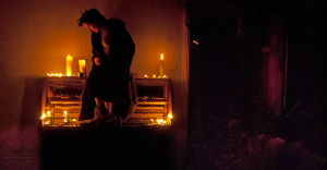 Partially nude girl on candlelit ruined piano